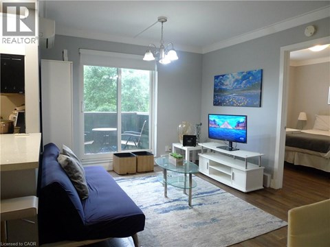 A living room with a blue couch and a television on a white stand.