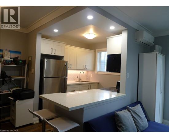A kitchen with a refrigerator, sink, and cabinets.