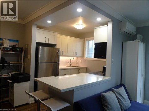 A kitchen with a refrigerator, sink, and cabinets.