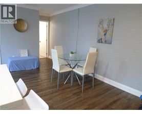 A dining room with a glass table and white chairs.