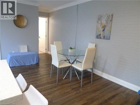A dining room with a glass table and white chairs.