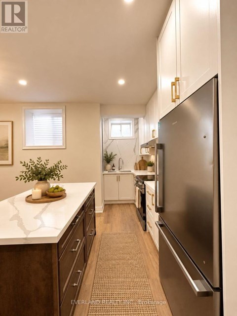 A kitchen with a refrigerator on the right side.