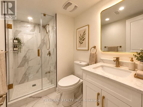 A bathroom with a marble shower and toilet.