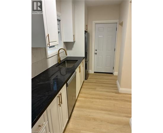 A kitchen with white cabinets and a black counter top.