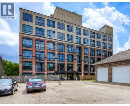 A large multi-story building with a parking lot in front.