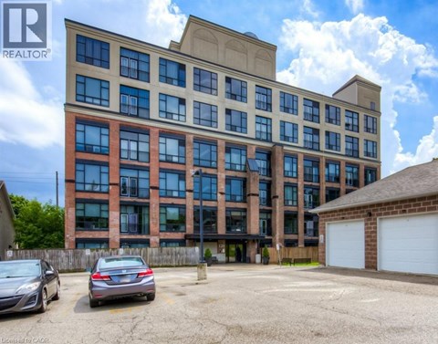 A large multi-story building with a parking lot in front.