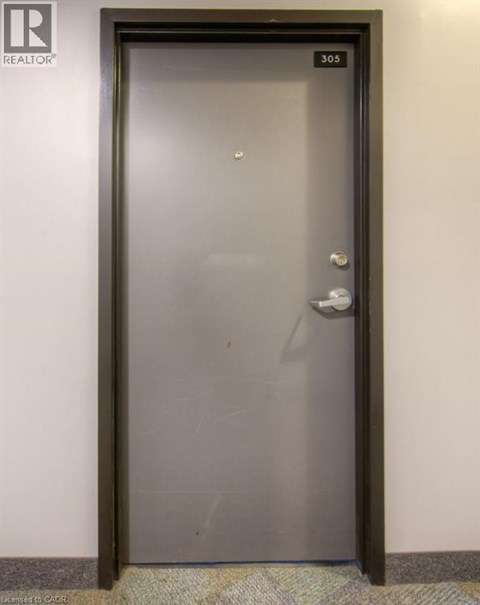 A door with a handle and a lock is numbered 305.