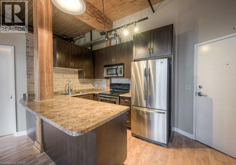 A kitchen with a granite countertop and stainless steel appliances.