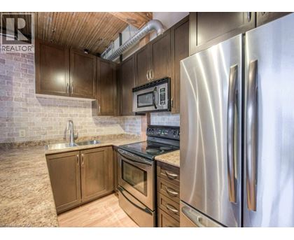 A kitchen with a stainless steel refrigerator and wooden cabinets.