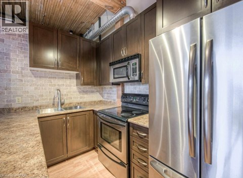 A kitchen with a stainless steel refrigerator and wooden cabinets.