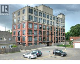 A multi-story building with a parking lot in front.