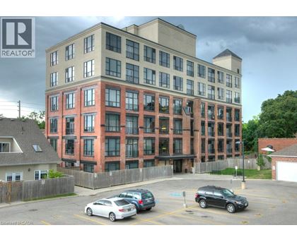 A multi-story building with a parking lot in front.