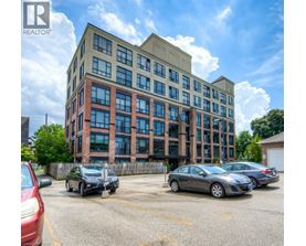 A parking lot with cars and a building with the logo REALTOR.