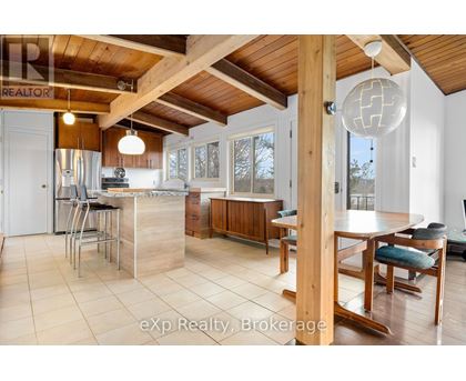 A kitchen with a wooden ceiling and a dining table with chairs.