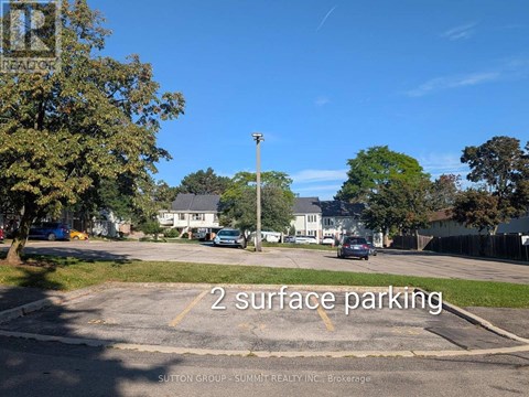 A parking lot with the words "2 surface parking" painted on the ground.