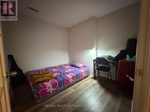 A bedroom with a bed, desk, and chair.
