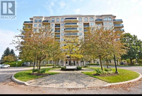 A large apartment building with a courtyard in front.