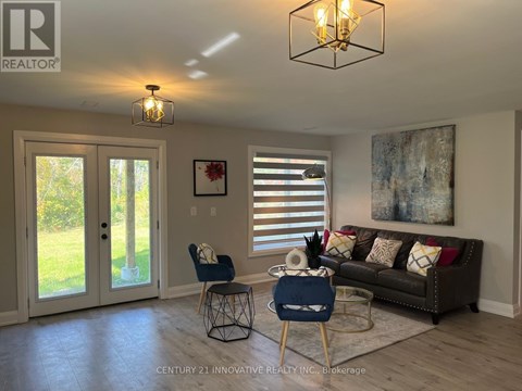 A living room with a couch, chair, and a painting on the wall.
