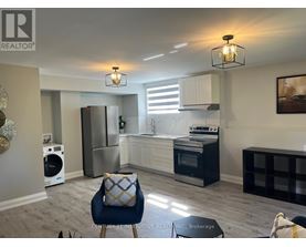 A modern kitchen with a blue chair and a fridge.