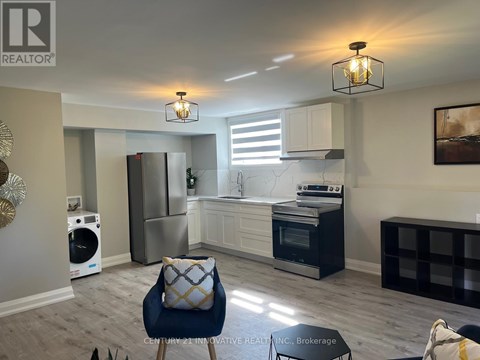 A modern kitchen with a blue chair and a fridge.