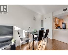A modern dining room with a glass table and chairs.