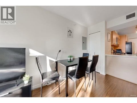 A modern dining room with a glass table and chairs.