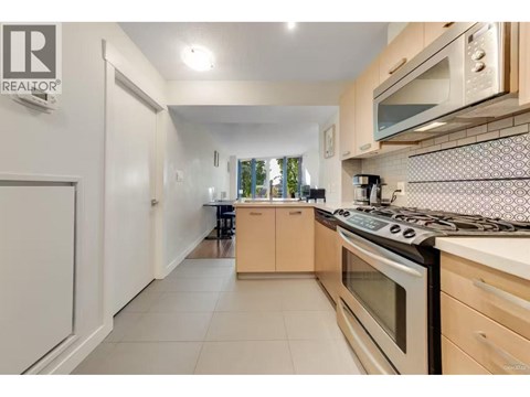 A kitchen with a stove top oven and a microwave above it.