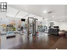 A gym with a variety of equipment including a treadmill, weights, and a rowing machine.