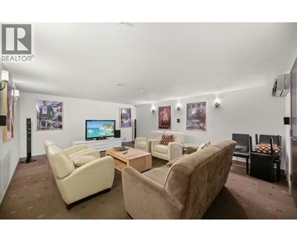 A living room with a couch, chairs, and a television.