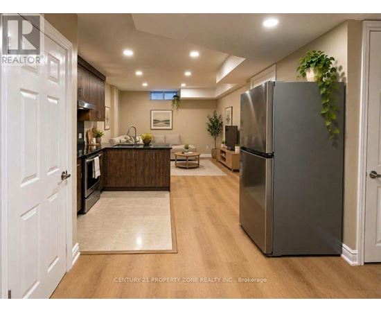 A modern kitchen with a refrigerator, sink, and dining area.