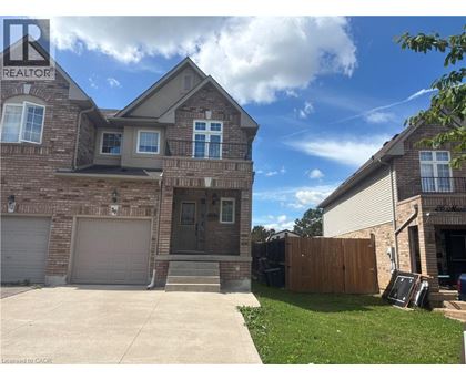 A house with a garage and a driveway in front of it.