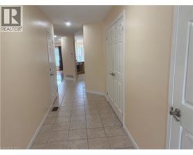 A hallway with tiled flooring and white doors.