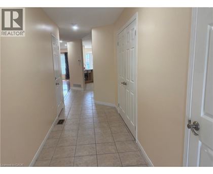 A hallway with tiled flooring and white doors.