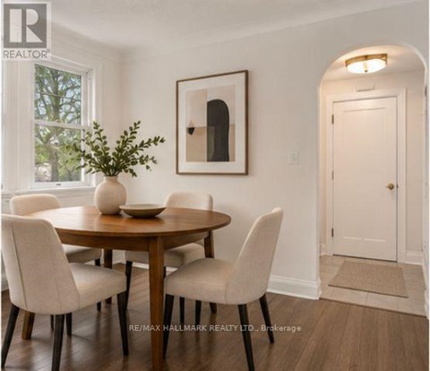 A dining room with a round table and chairs.
