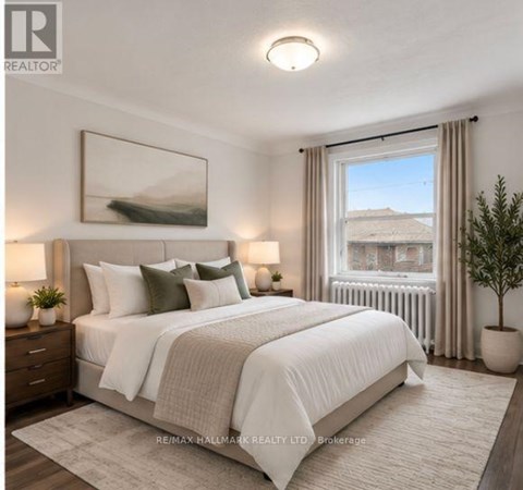 A bedroom with a large bed, a window with a view, and a painting on the wall.