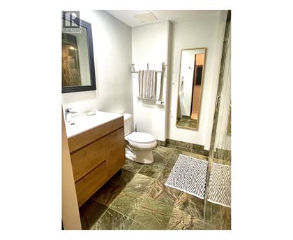 A bathroom with a toilet, sink, and shower.