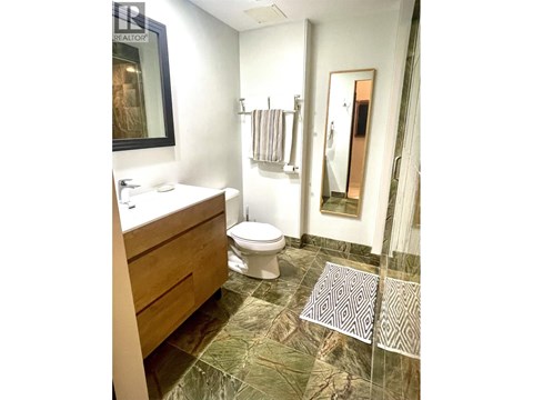 A bathroom with a toilet, sink, and shower.