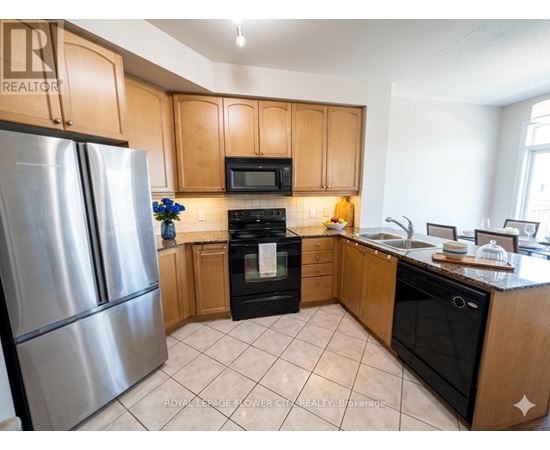 A kitchen with wooden cabinets and a stainless steel refrigerator.