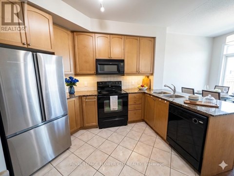 A kitchen with wooden cabinets and a stainless steel refrigerator.