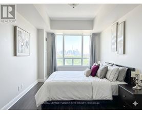 A bedroom with a large bed and a view of the city.