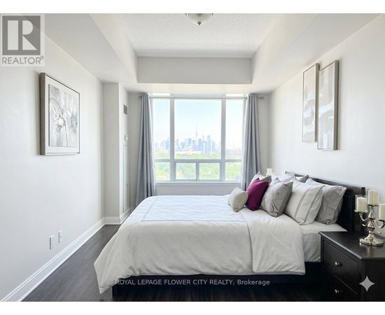 A bedroom with a large bed and a view of the city.
