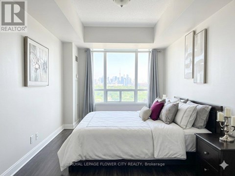 A bedroom with a large bed and a view of the city.