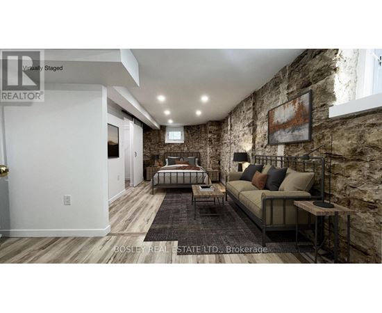 A bedroom with a stone wall and a bed with a metal frame.