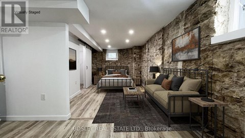 A bedroom with a stone wall and a bed with a metal frame.