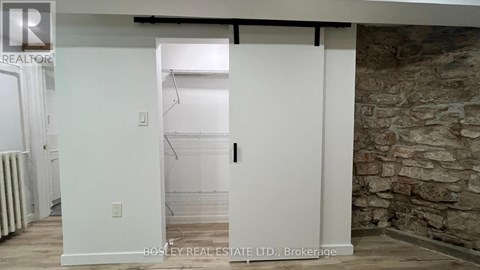 A room with a stone wall and a doorway leading to another room.