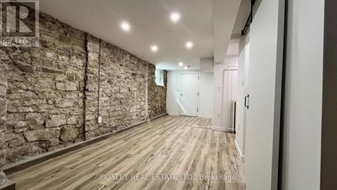 A room with wooden floors and a stone wall.