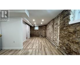 A room with wooden floors and stone walls.