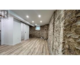 A room with a stone wall and wooden flooring.