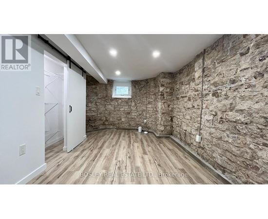 A room with wooden floors and stone walls.