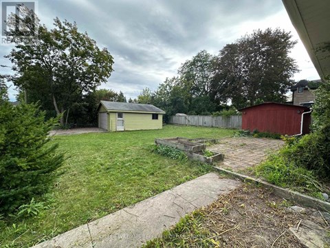 A backyard with a shed and a red barn.